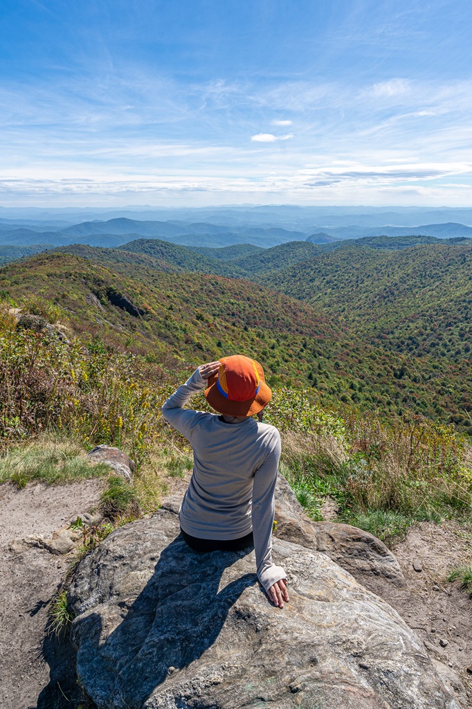 Woman sitting on rock looking at the views from Tennent Mountain.