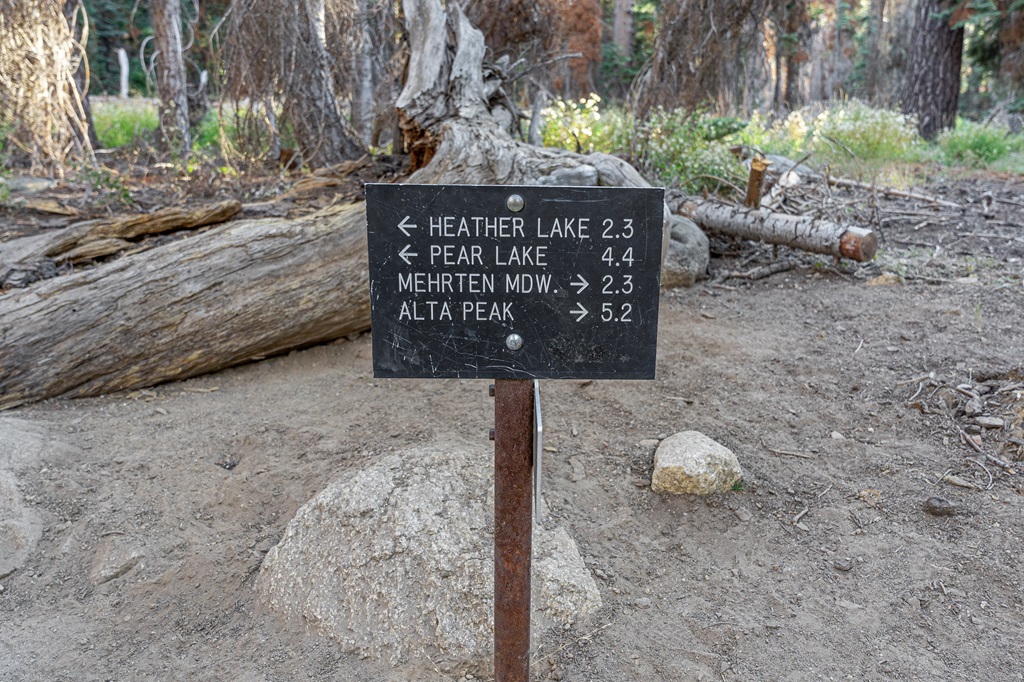 Trail sign with arrows pointing to the left towards Heather and Pear Lake and another arrow pointing to the right towards Alta Peak.