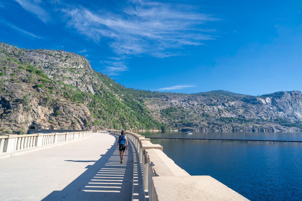 Man walking across the O'Shaughnessy Dam in Hetch Hetchy.