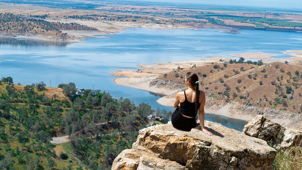 Woman sitting on a rocky outcrop at Pincushion Peak in California.