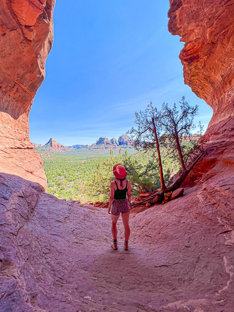 Woman standing in the Birthing Cave looking out at the views.