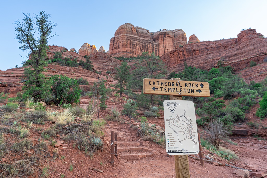 Trail sign indicating Cathedral Rock Trail continues straight with Cathedral Rock in the background.