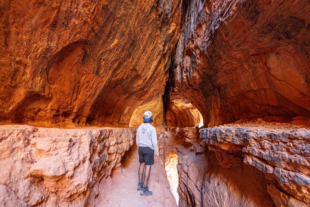 Man standing inside the Soldiers Pass Cave.