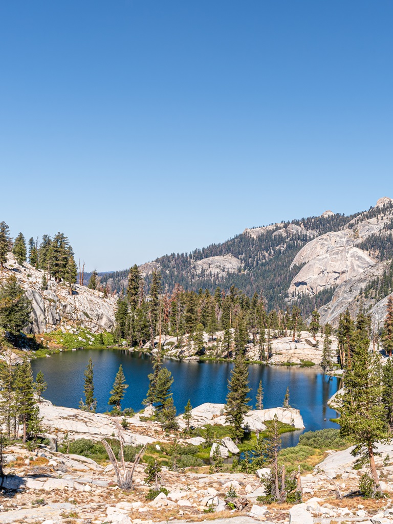 View of a dark blue alpine lake known as Aster Lake from the Lakes Trail in Sequoia National Park.