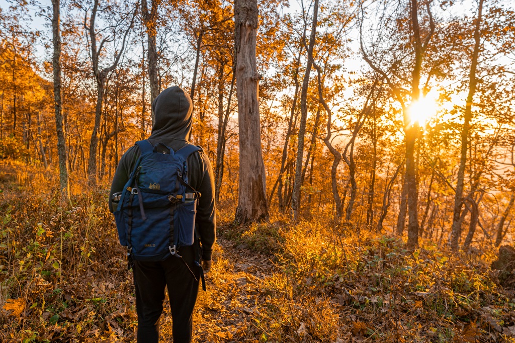 Man standing on the Sharp Top Trail during sunrise.