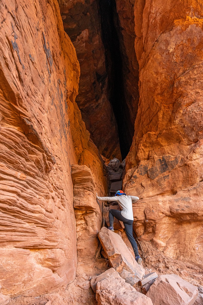 Woman scrambling up the Soldier Pass Cave entrance.