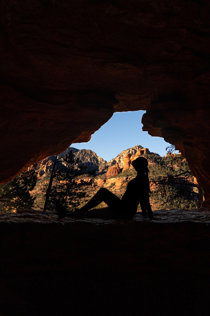 Woman posing for a picture at the window inside the Soldier Pass Cave in Sedona.