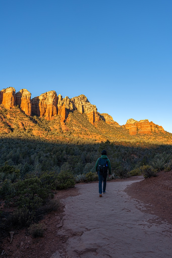 Man hiking along the Soldier Pass Trail in Sedona during sunrise.