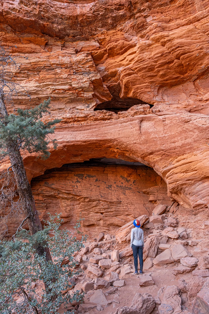 Woman standing in front of the Soldier Pass Cave in Sedona.