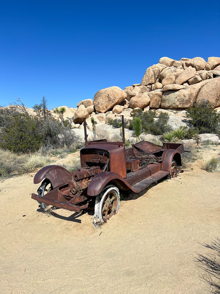 Old rusty red car located along the Wall Street Mill Trail in Joshua Tree National Park.