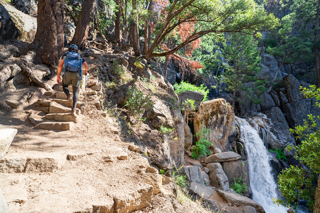 Man hiking along the trail with the lower portion of Chilnualna Falls to the right.