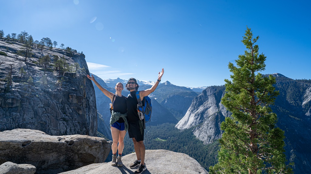 Man and woman posing for a picture at the Yosemite Falls Overlook.