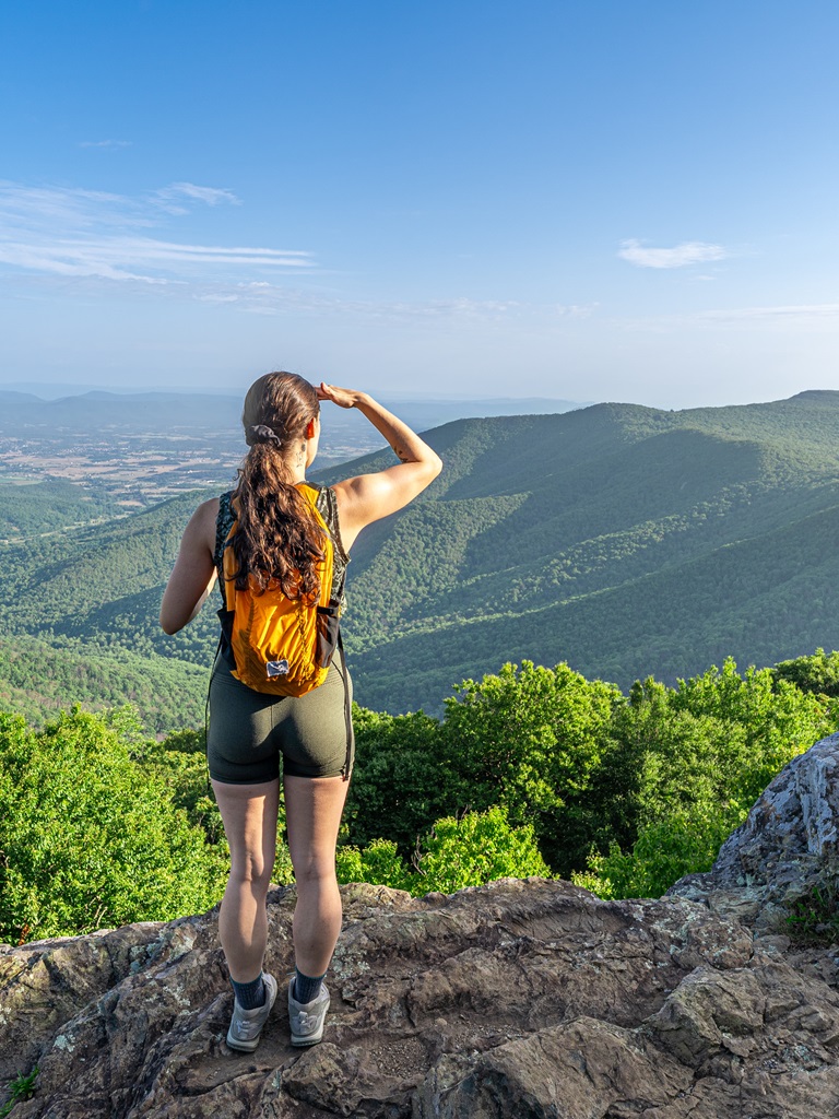 Woman looking at the views from Hawksbill Summit in Shenandoah National Park.