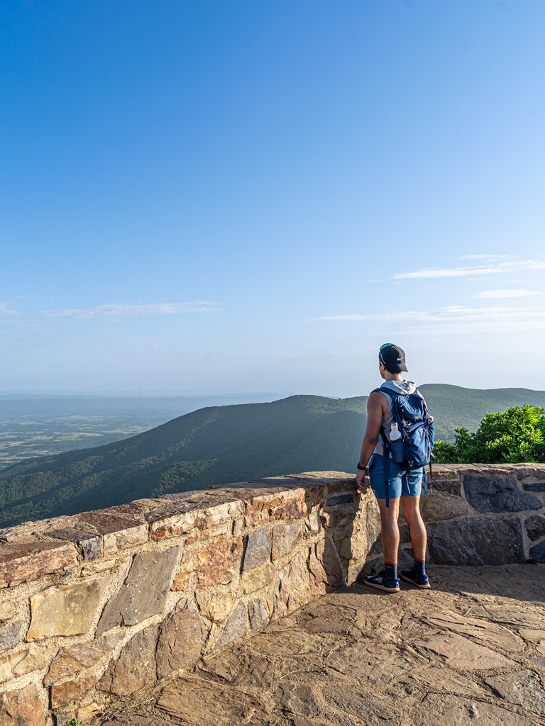 Man looking at the views from the viewing platform at Hawksbill Summit Shenandoah.