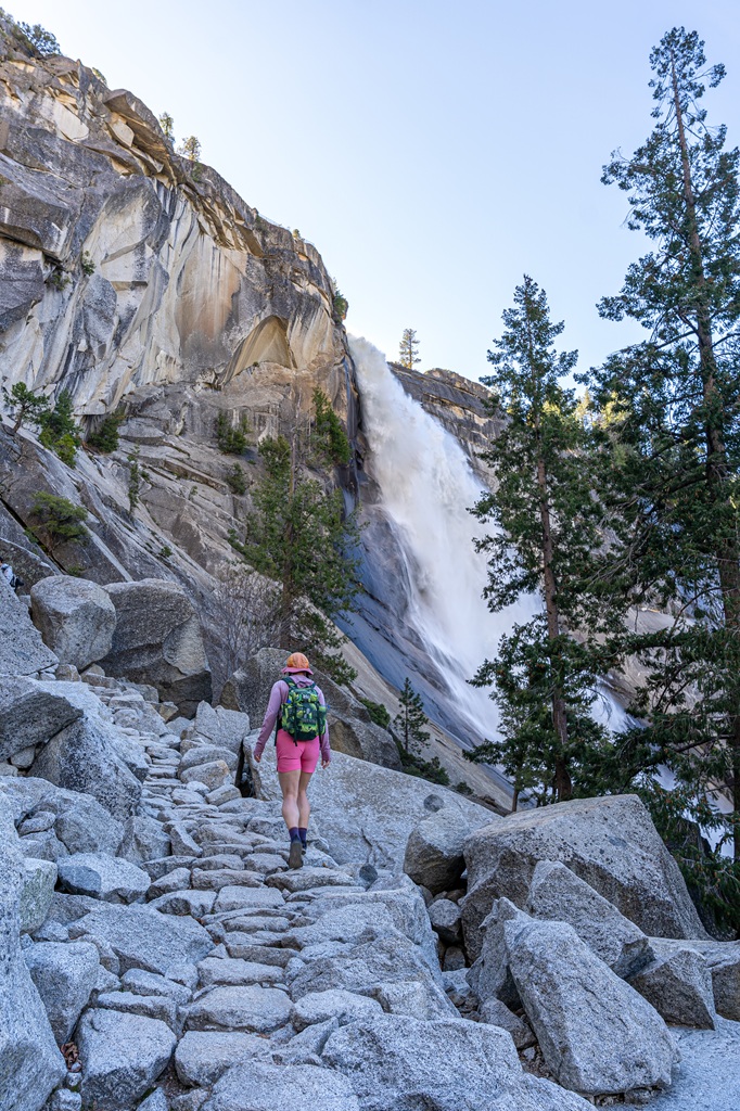 Woman hiking up the Mist Trail to the top of Nevada Fall in Yosemite National Park.