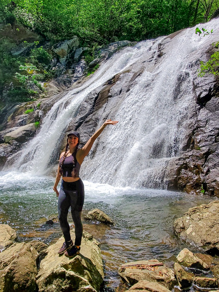 Woman standing on rock near Whiteoak Canyon Falls #1 located along the Whiteoak Canyon Trail in Shenandoah National Park.