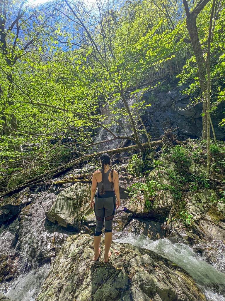 Woman standing in front of Whiteoak Canyon Falls #2 located in Shenandoah National Park.