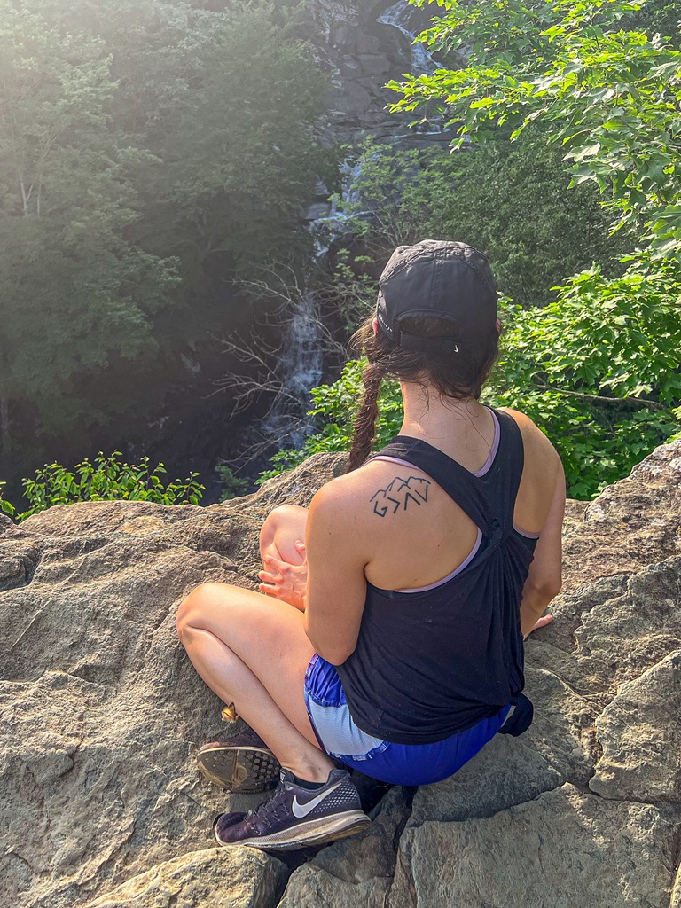 Woman sitting at the overlook of Whiteoak Canyon Falls #6 in Shenandoah National Park.