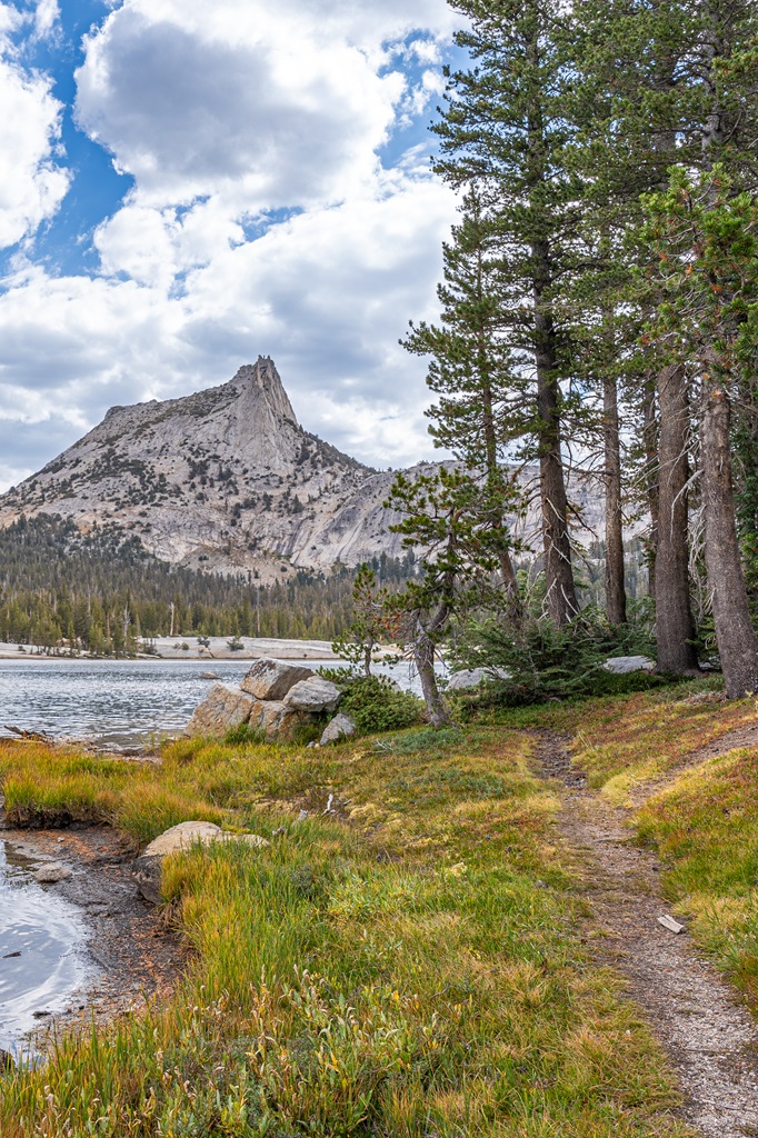 Hiking along a trail that goes around Lower Cathedral Lake with Cathedral Peak in the background.