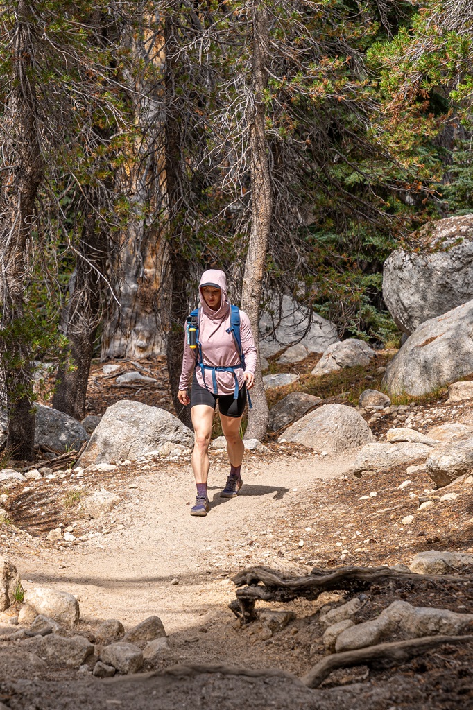 Woman hiking along the John Muir Trail towards Cathedral Peaks in Yosemite.