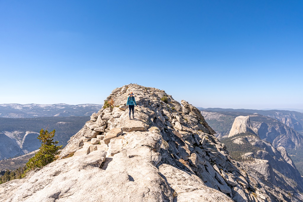 Woman standing on the ridge of Clouds Rest in Yosemite.