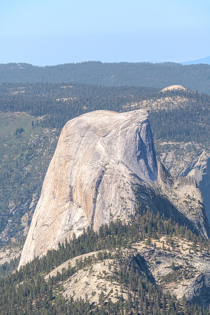 Close-up view of Half Dome and people climbing the cables to reach the top.