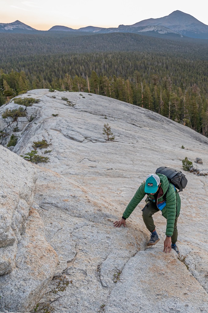 Man scrambling to the top of Lembert Dome in Yosemite.