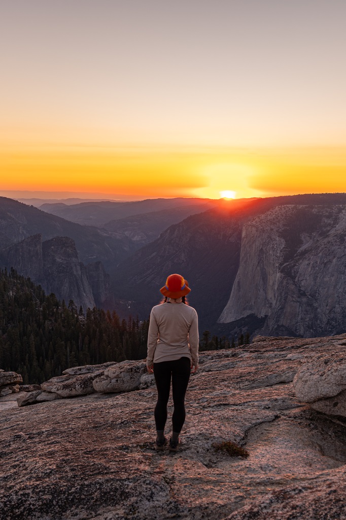 Woman watching the sunset from Sentinel Dome with El Capitan in the distance.