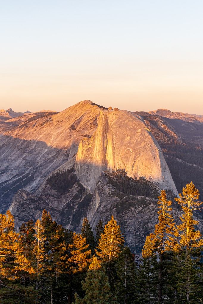 View of Half Dome during sunset from Sentinel Dome with a golden light shining on Half Dome.