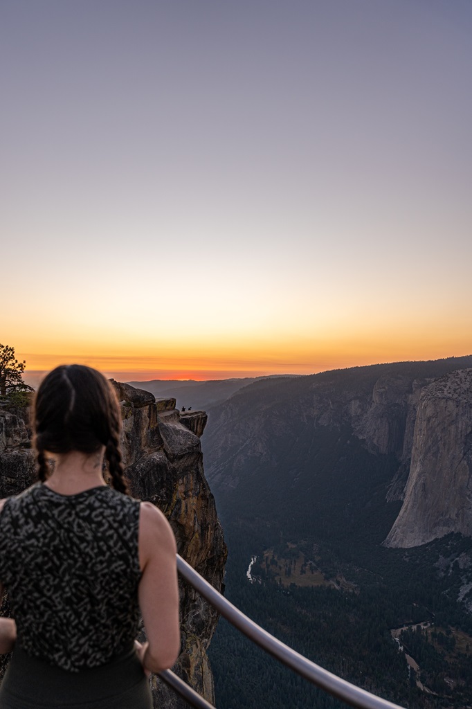 Woman watching the sunset from a viewpoint at Taft Point.