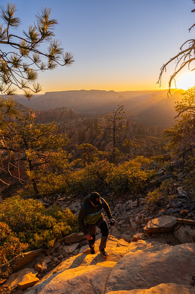 Man hiking along the Bear Mountain Trail during sunrinse in Sedona.