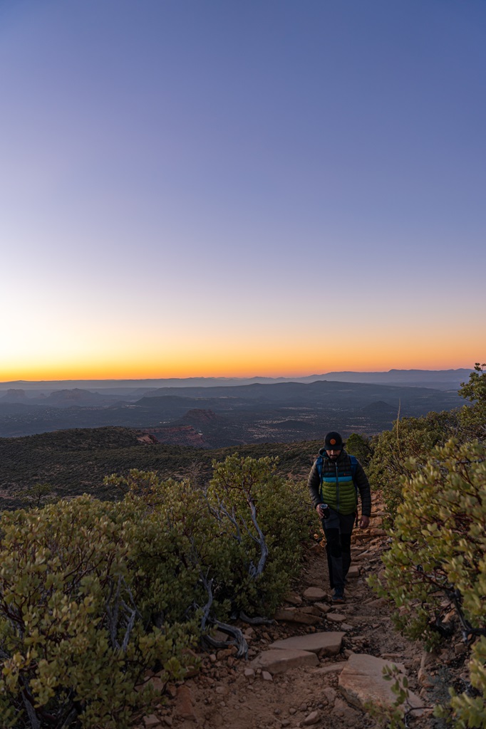 Man hiking along the Bear Mountain Trail during sunrise in Sedona.