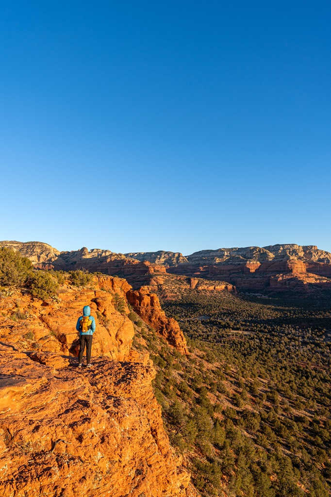 Woman standing on a rocky outcrop on Doe Mountain in Sedona.