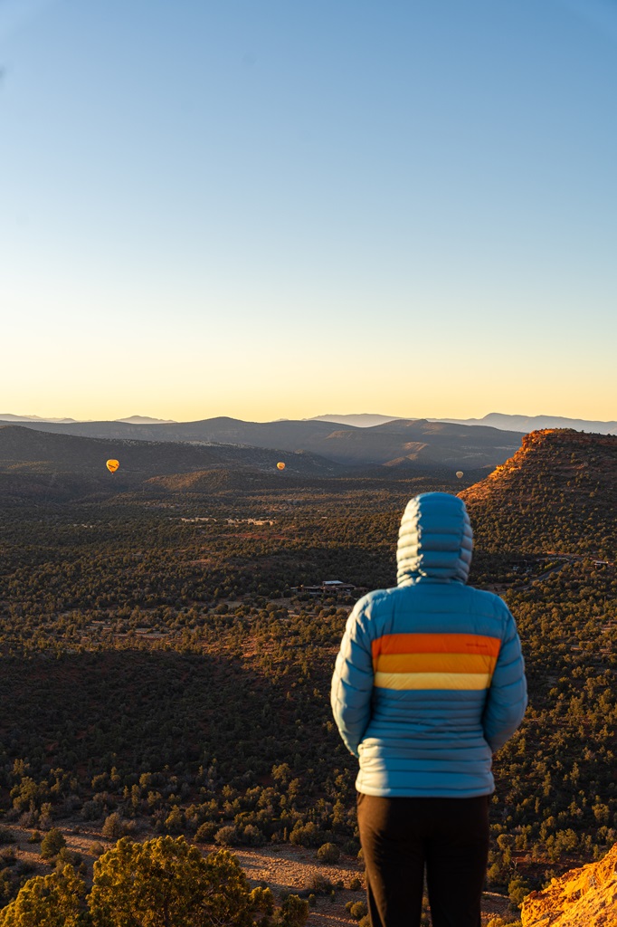 Woman watching hot air balloons from Doe Mountain in Sedona.