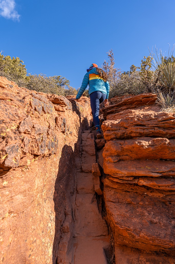 Woman tackling a rock scrambling section along the Doe Mountain Trail in Sedona.