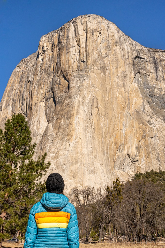 Woman standing in El Capitan Meadow looking up at El Capitan in Yosemite.