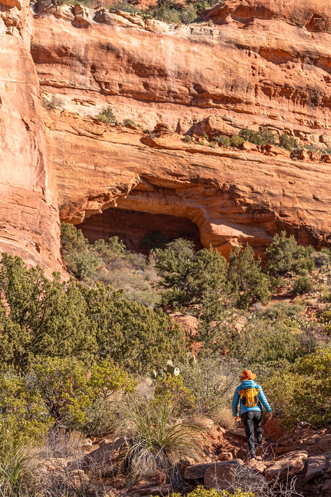 Woman walking along a social trail towards Fay Canyon Arch in Sedona.