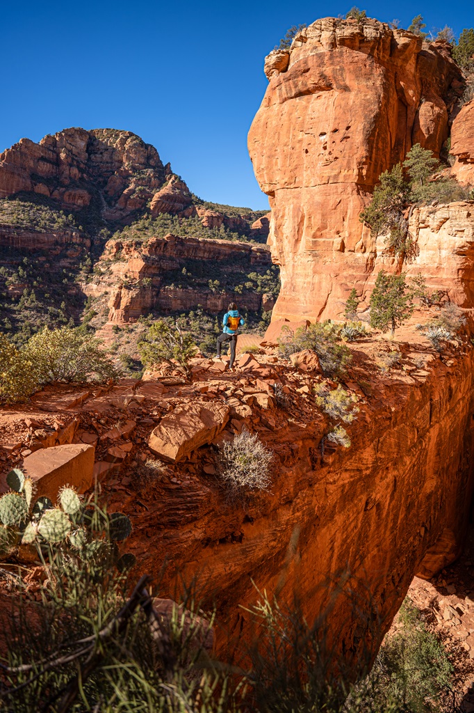 Woman standing on top of Fay Canyon Arch in Sedona.