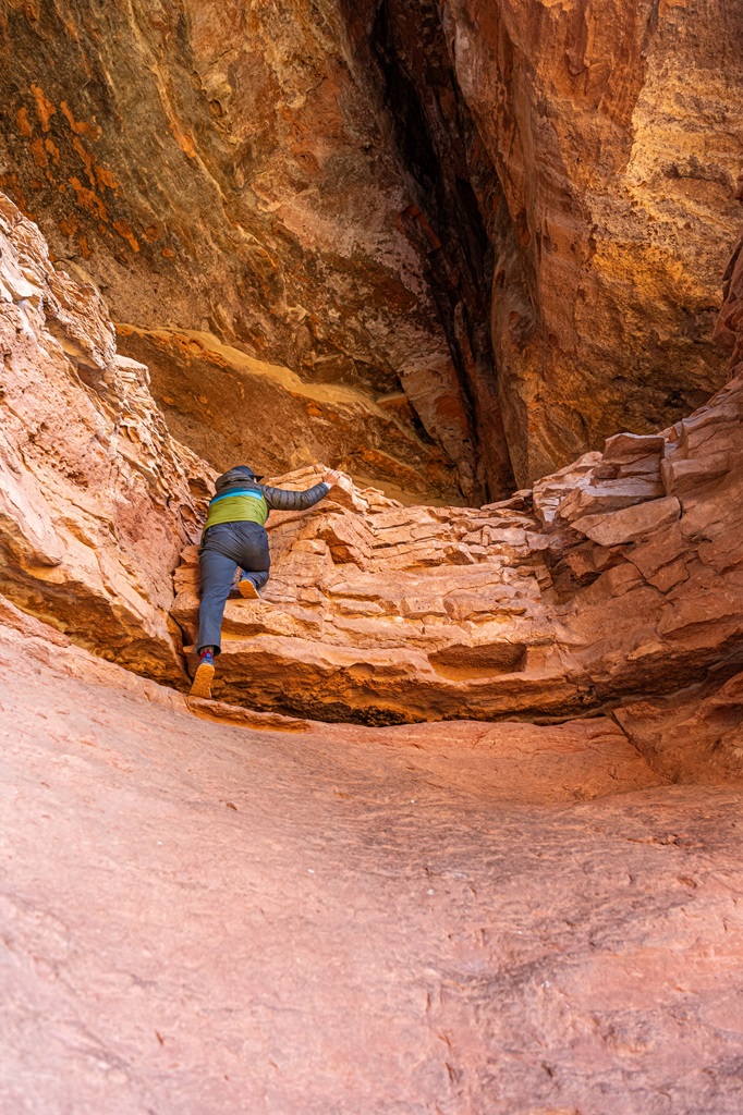 Man climbing a class III route into the Keyhole Cave in Sedona.