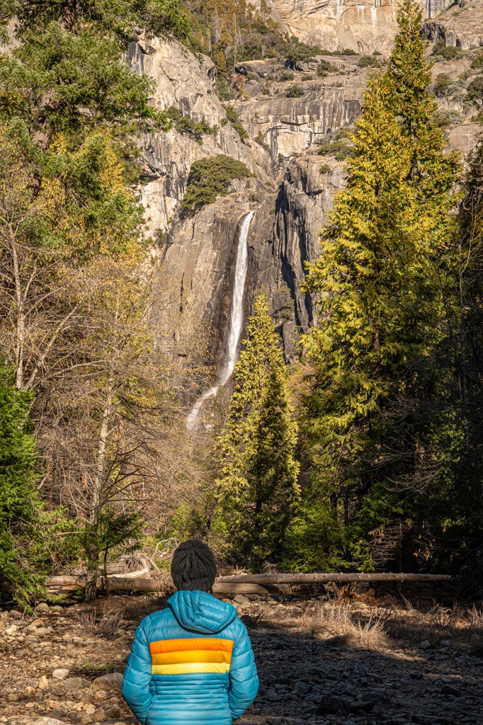 Woman looking at Lower Yosemite Point from a vista point along the trail in Yosemite.