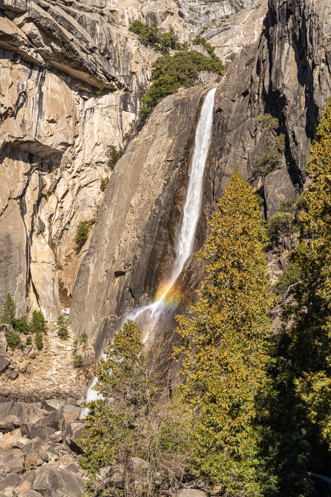 View of Lower Yosemite Fall and a rainbow at its base from the Lower Yosemite Fall Footbridge.