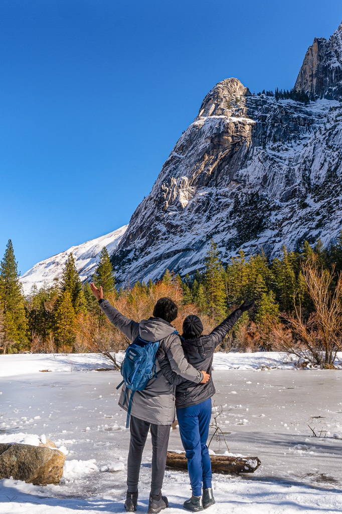 Man and woman standing in front of the frozen Mirror Lake during winter.