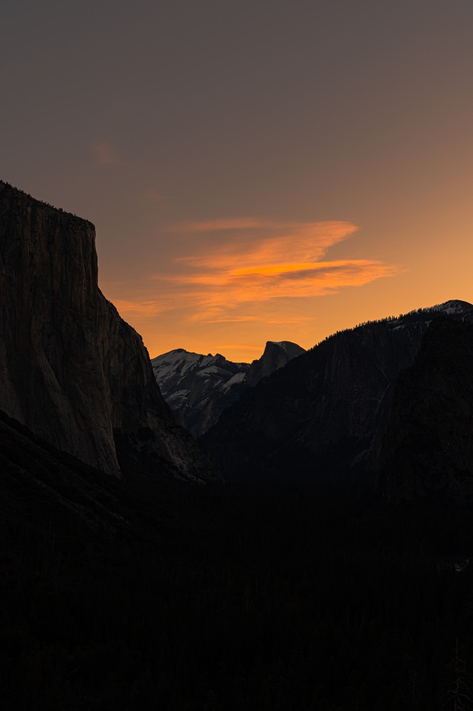 Bright orange sunrise colors in the sky at Tunnel View in Yosemite National Park.