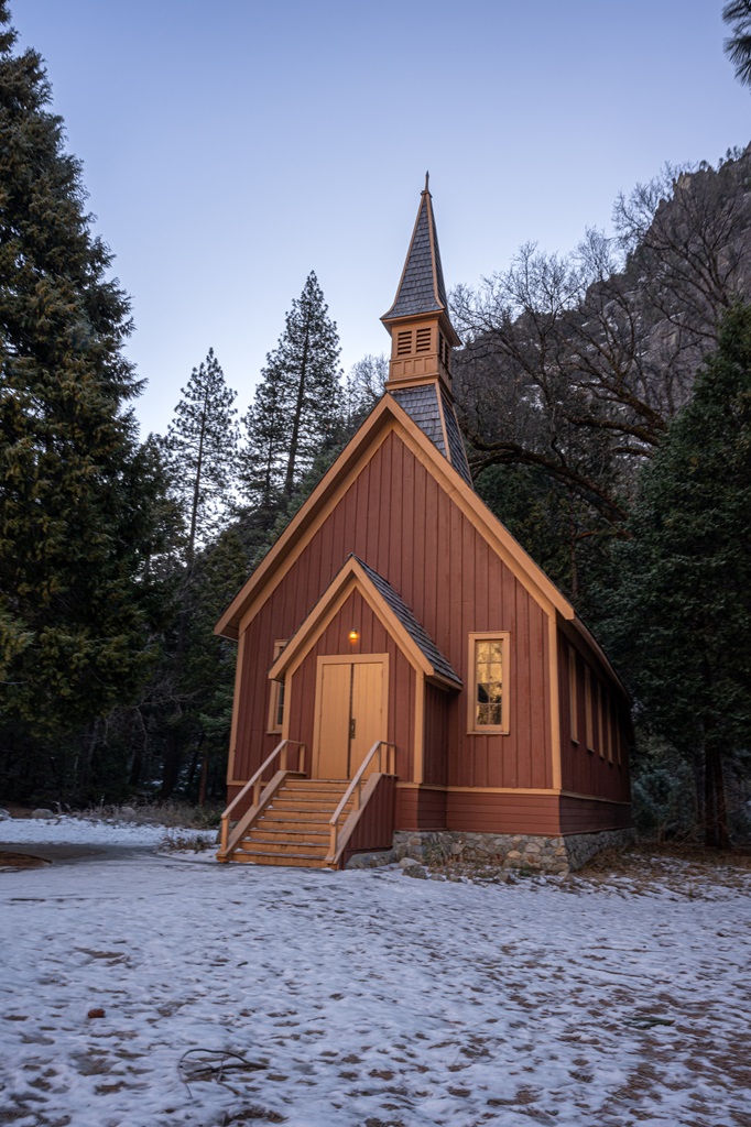 Yosemite Valley Chapel in winter with a dusting of snow on the ground.