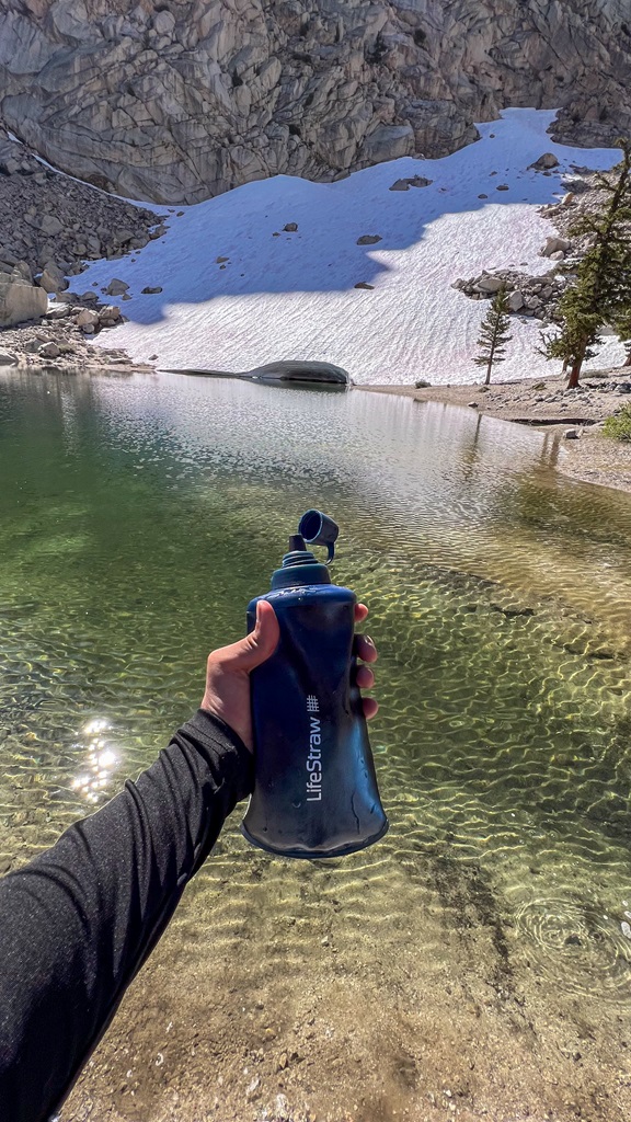 Man holding a LifeStraw water filter in front of Lone Pine Lake in the Mt Whitney area.