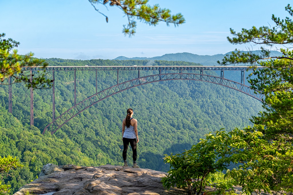 Woman admiring the view of the New River Gorge Bridge from the Long Point Overlook.