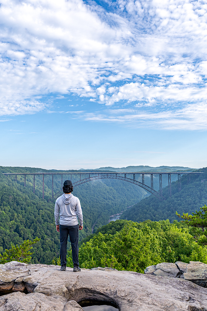 Man standing at Long Point Overlook admiring the view of the New River Gorge and New River Gorge Bridge.