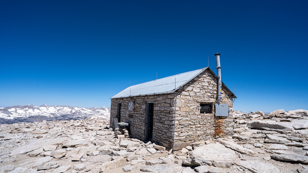 Stone hut at the summit of Mt Whitney on a clear, sunny day.