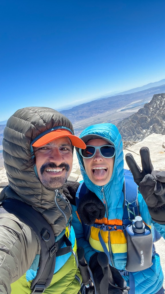 Man and woman posing for a selfie on the summit of Mt Whitney.