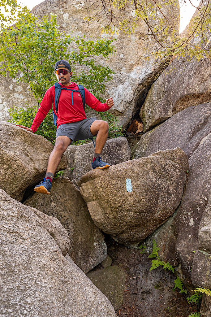 Man climbing down a rock along the Old Rag Rock Scramble in Virginia.